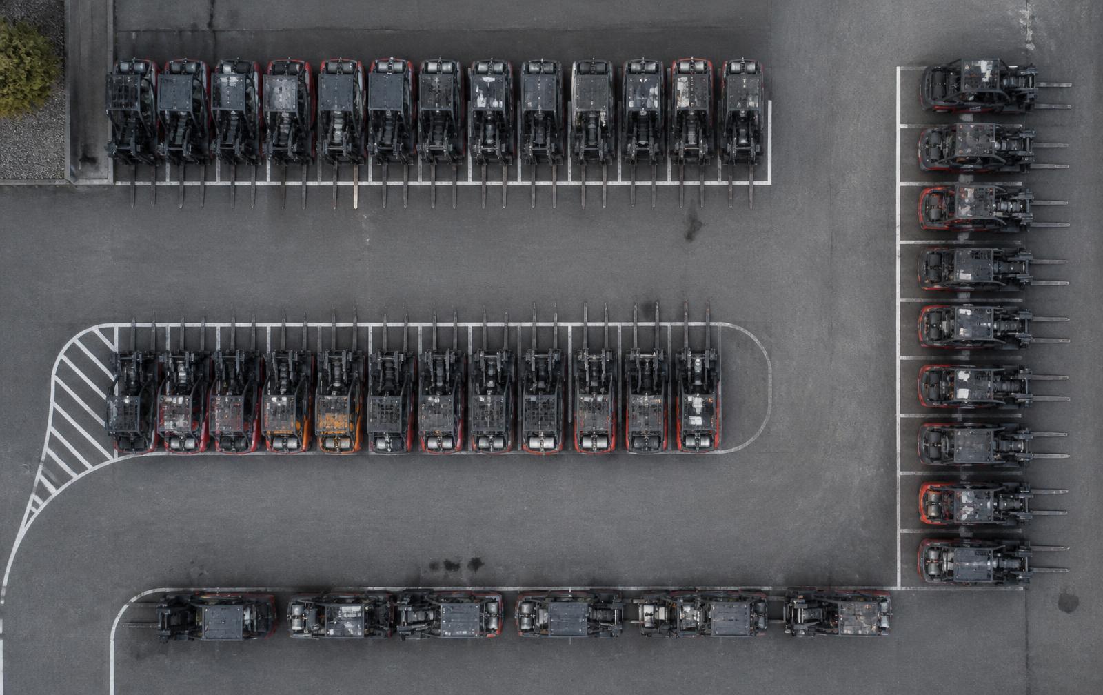 Aerial view of forklifts parked in rows across a graphite yard